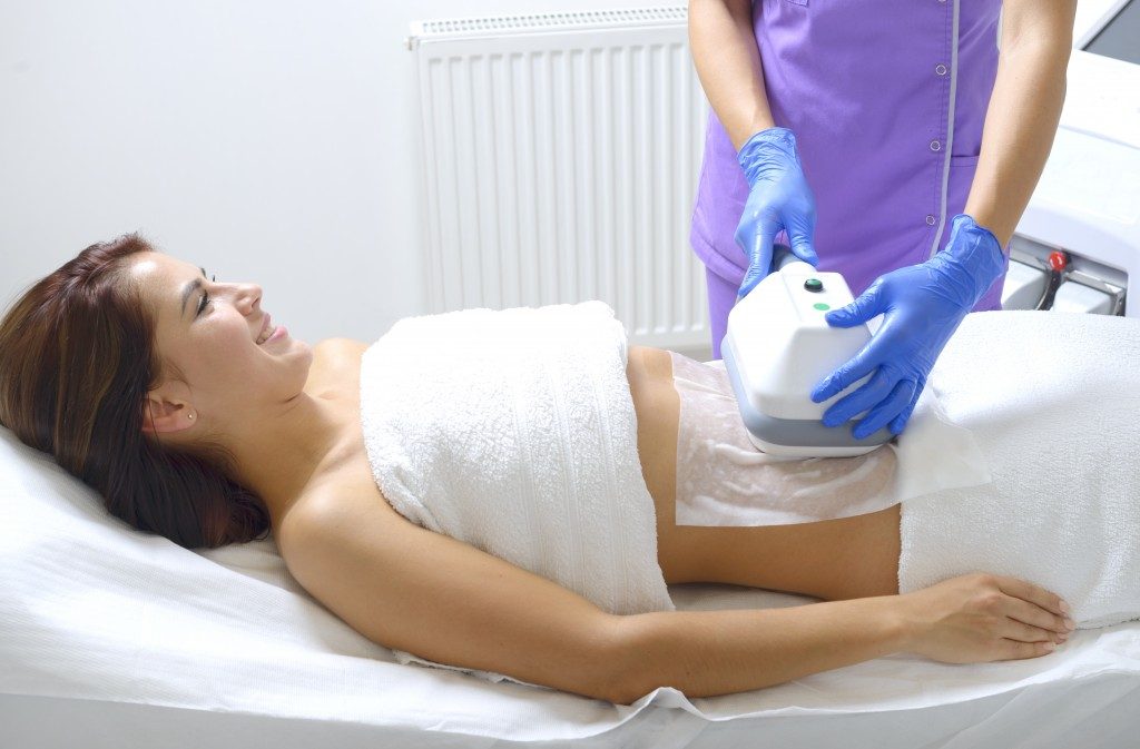 Pretty young woman getting cryolipolyse treatment