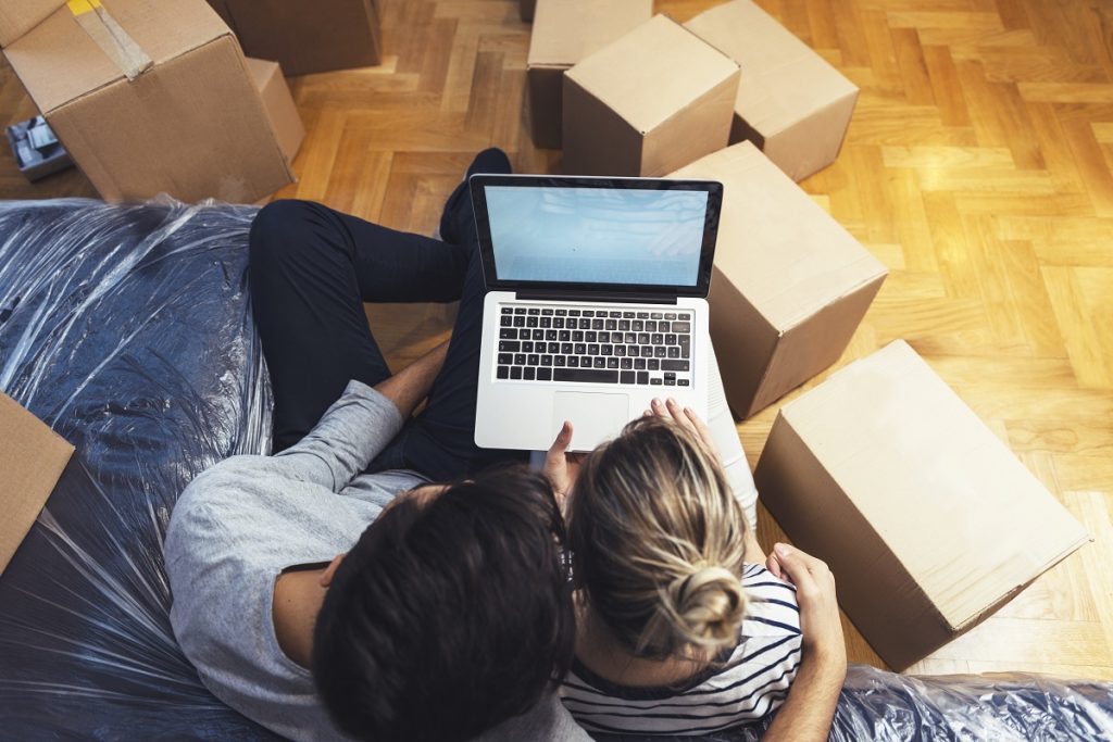 Couple using laptop while moving
