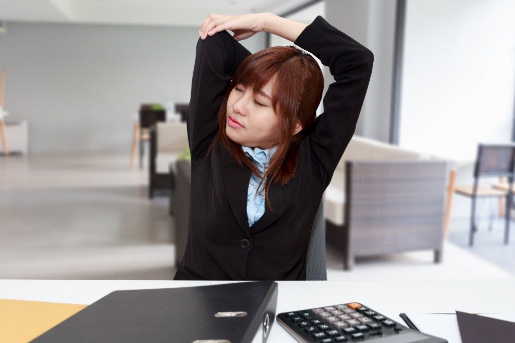 Businesswoman stretching herself or exercise while working at office