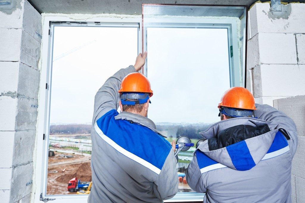 construction workers replacing window