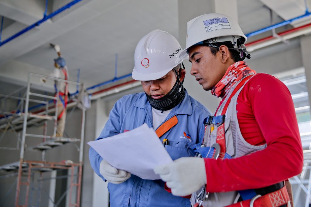 Two construction workers reading a document