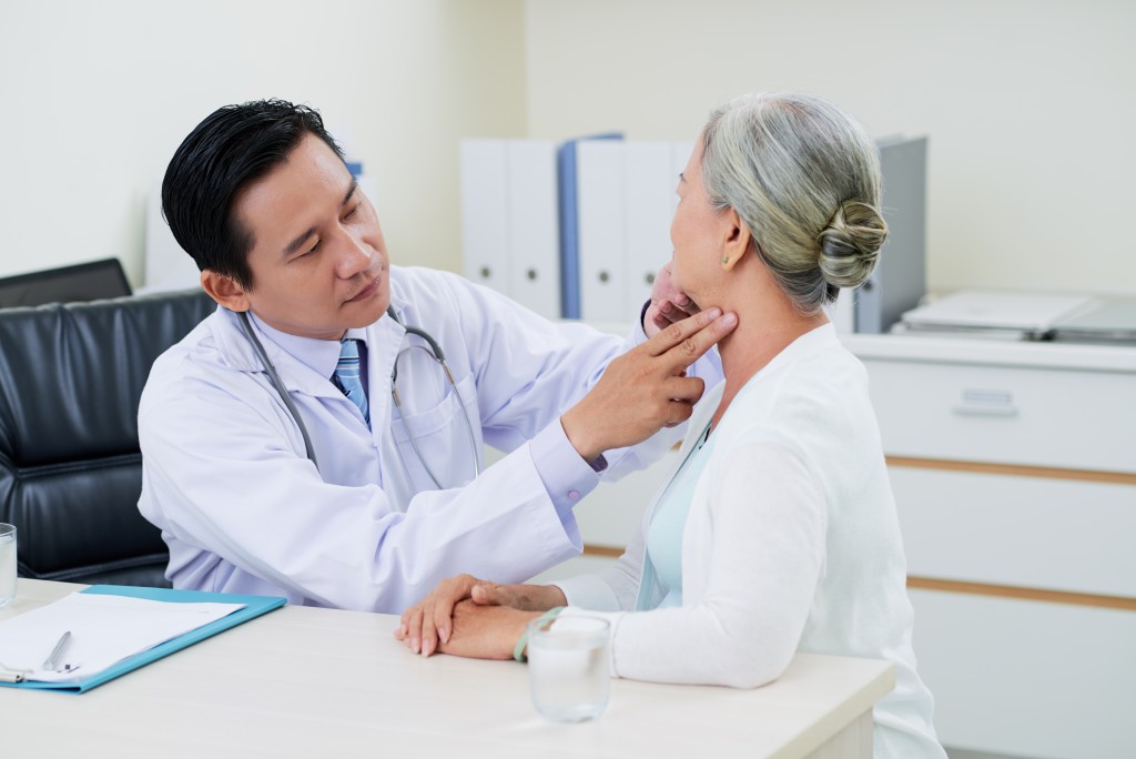 doctor examining old woman