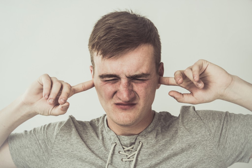 man covering his ears