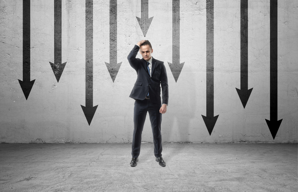 man in suit with black arrows behind him