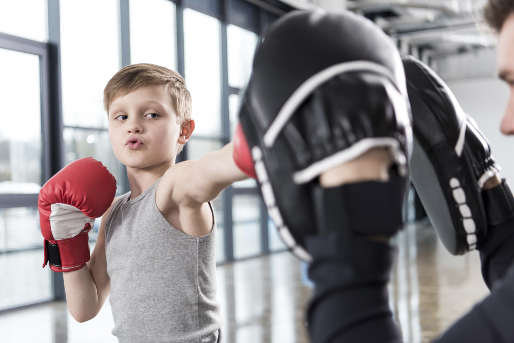 Kid doing boxing with his trainer 