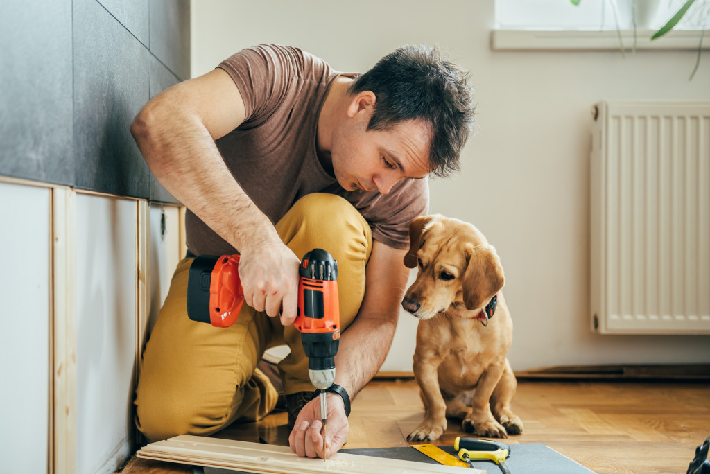 man doing renovation with his dog