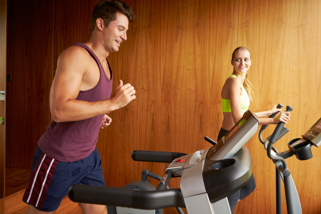 Young couple exercising at home using treadmills. 