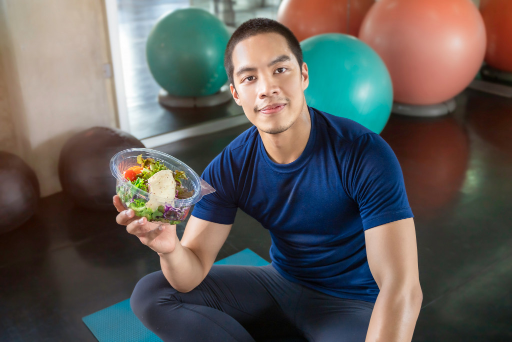 fit man eating a bowl of healthy food