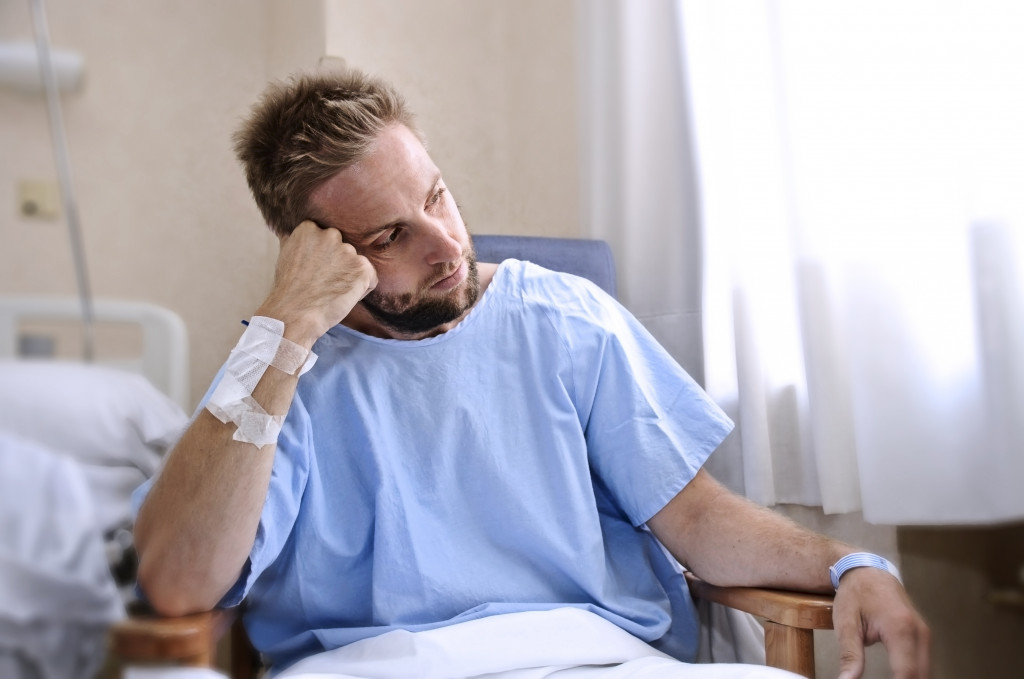 injured man in hospital room feeling isolated