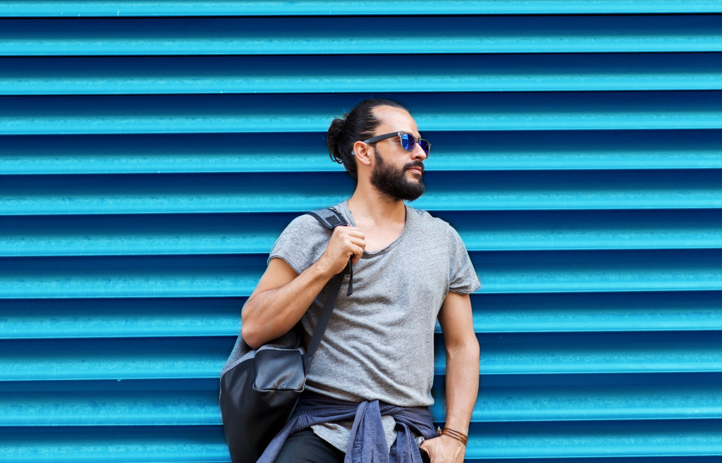 travel concept shown through a man wearing sunglasses with backpack