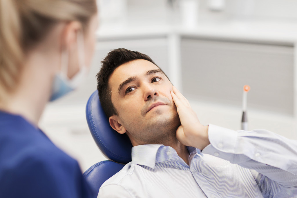 A male patient with jaw pain having a dental consultation in a dental clinic