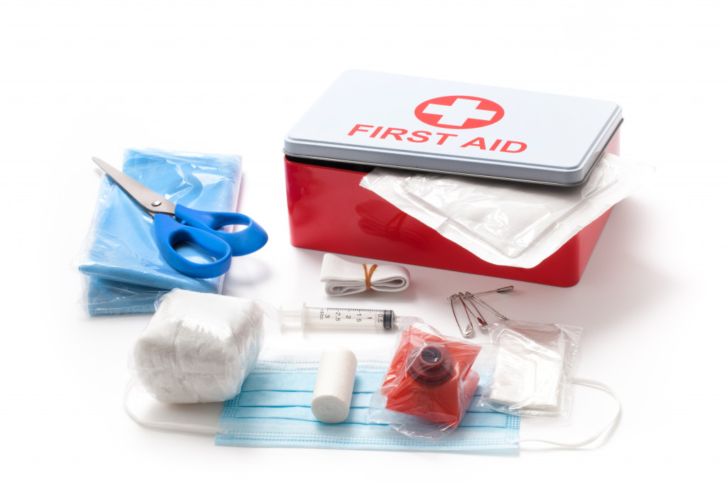 First aid kit placed on a white floor.