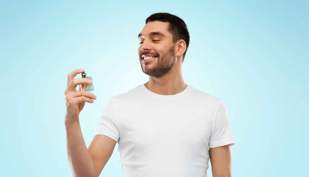 A man spraying perfume on himself