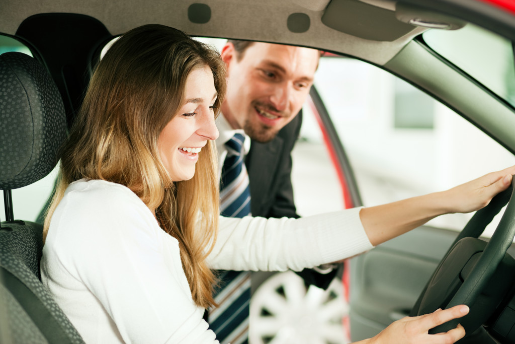 Female driver checking a car with a rep answering her questions.