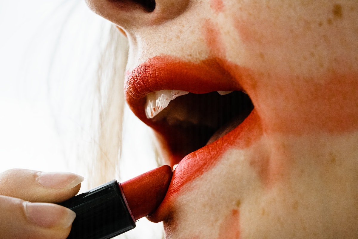 woman-putting-on-red-lipstick