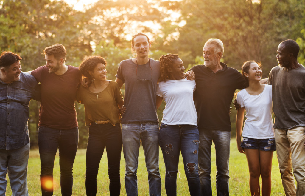 Group of diverse people standing beside each other in a park.