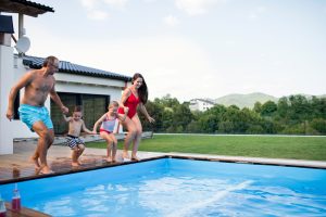 family jumping into the swimming pool