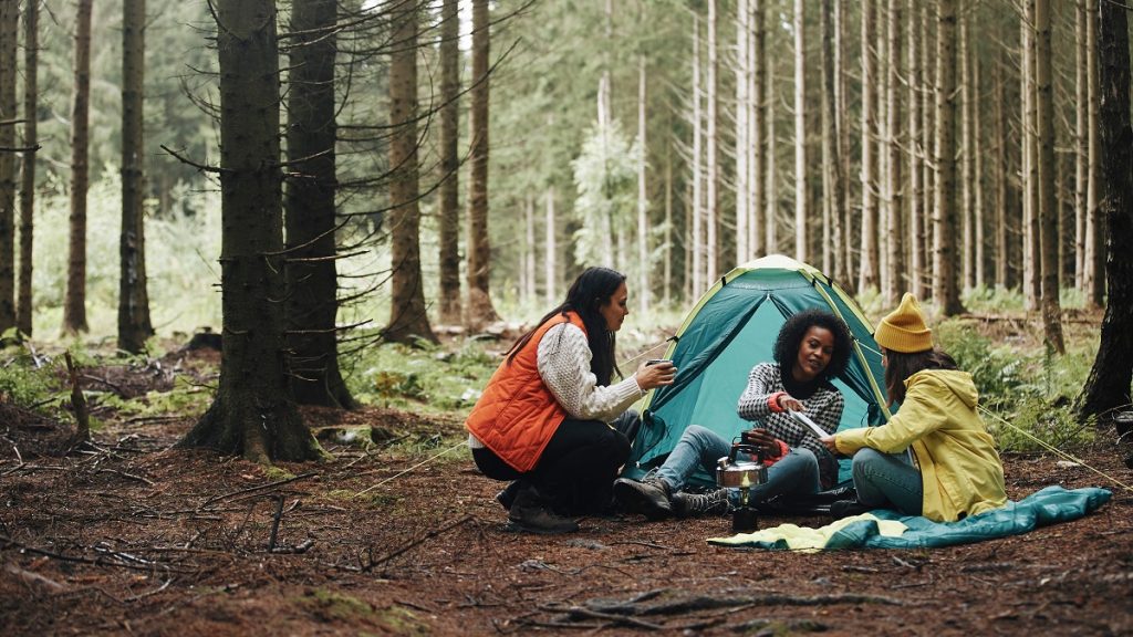 female friends sitting at the forest campsite